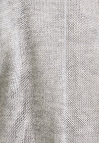 Jasnoszara dziana tkanina o zróżnicowanej fakturze, prezentująca gładki i lekko prążkowany wzór, subtelnie łącząca kolory i style.