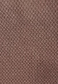 Tissu texturé dans une couleur brun rougeâtre atténuée avec un motif en grille, présentant un tissage fin et une texture douce, légèrement rugueuse.