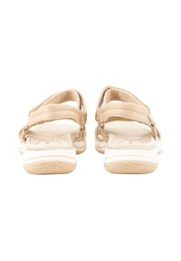 Sandalias beiges con correas ajustables dobles, suelas texturizadas y una suela de goma blanca con un patrón de tracción.