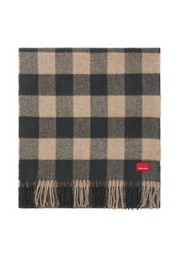 Geweven plaid sjaal in tan en zwart, met franjes aan de randen. Bevat een klein rood label aan de zijkant. Zachte textuur.