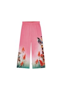 Ružičaste široke hlače s šarenim životinjskim i cvjetnim uzorkom, koje prikazuju žirafu sa sunčanim naočalama i zeca protiv zelenih i crvenih naglasaka.
