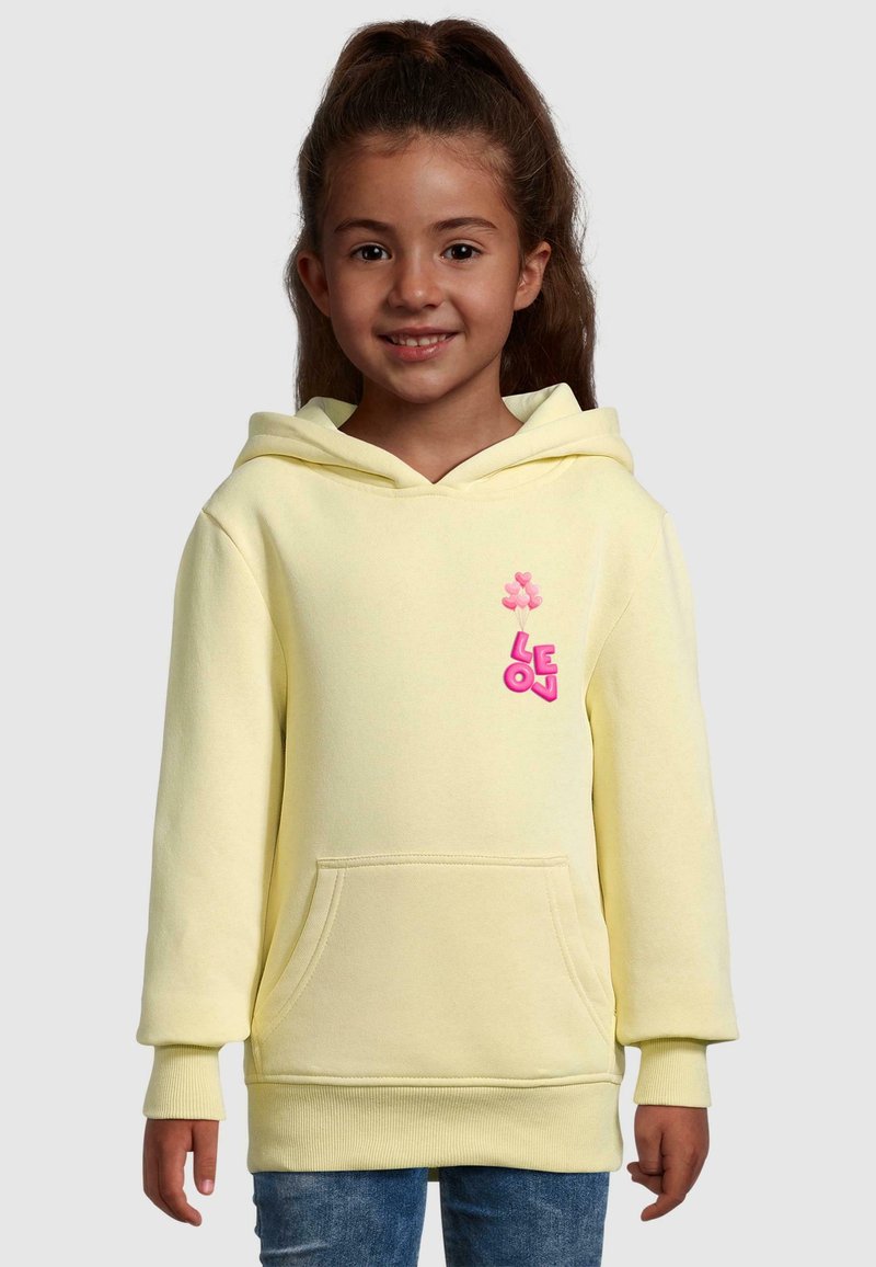 Żółta bluza z kapturem wykonana z miękkiej tkaniny, z kieszonką z przodu. Posiada różową grafikę balonu i logo na lewej piersi. Ribbowane mankiety i dół.