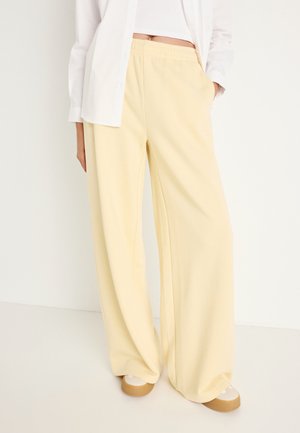 WIDE - Tracksuit bottoms - banana crepe