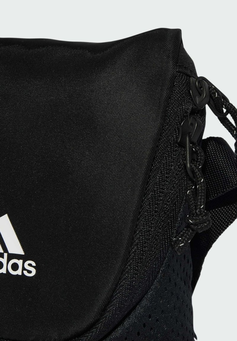 Zwarte Adidas schoudertas met rits aan de voorkant, verstelbare riem en wit Adidas-logo op de stof.