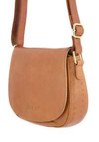 Karamelbrun læder crossover taske med en buet klaft, guldfarvet hardware og struktureret side. Har en justerbar rem og prægede logo.