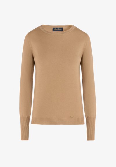 Beige neulepusero, jossa on pyöreä pääntie ja pitkät hihat. Siinä on ribbireunukset helmassa ja hihoissa, sekä pieni kultainen logo-yleisö alaosassa.