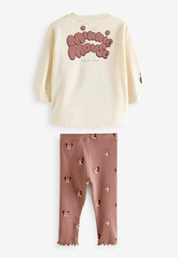 Minnie Mouse'i kaheosaline komplekt, mis sisaldab kreemikat pulloverit pruuni graafika ja roosa aktsendiga mustriga retuusidega. Pehmest puuvillasegust materjalist, mugav lõige.