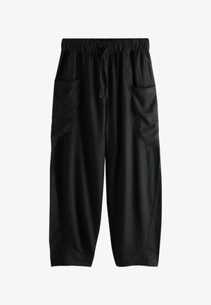 Laza fekete nadrág gumis derékkal, zsinórral és nagy oldalzsebekkel, puha anyagból készült.