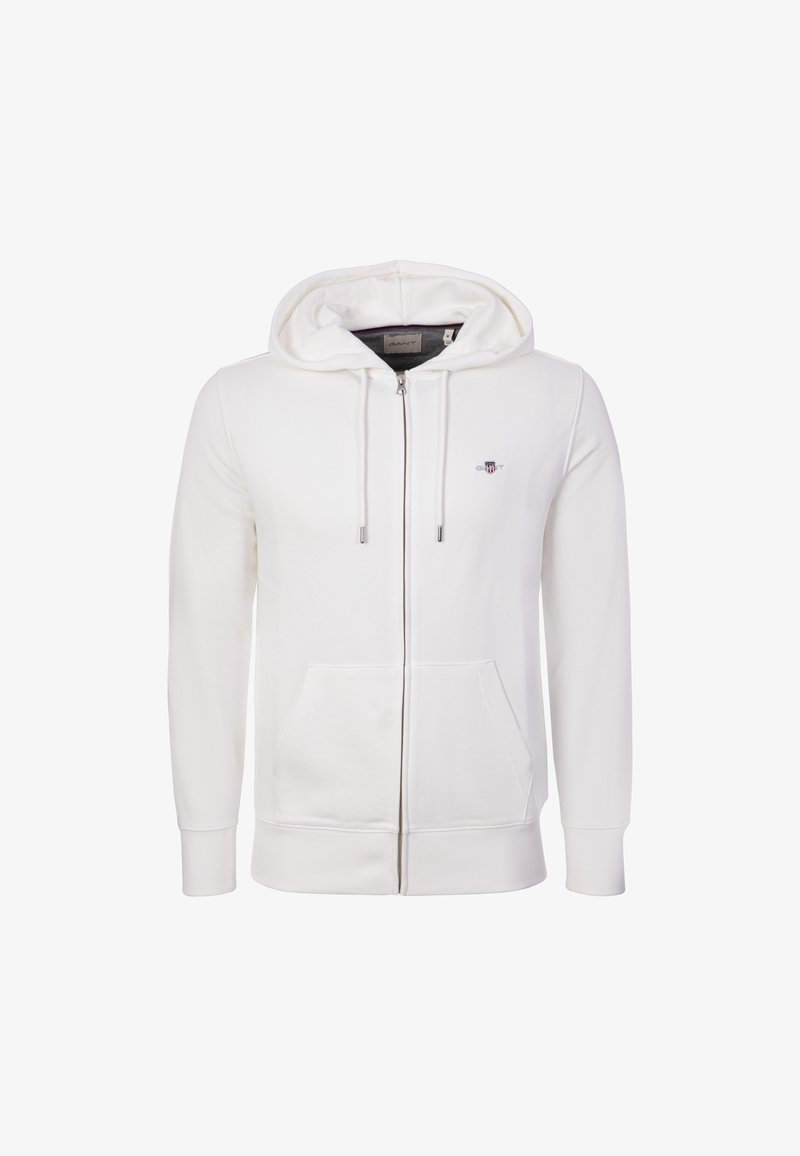 Sudadera blanca con cremallera completa, bolsillos frontales, capucha con cordón, puños acanalados y un pequeño logo bordado en el pecho izquierdo.