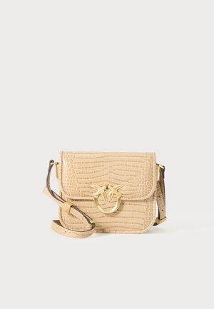 Beige crocodile-embossed leather bag with a gold-tone bird emblem, vertical flap design, and a detachable shoulder strap.