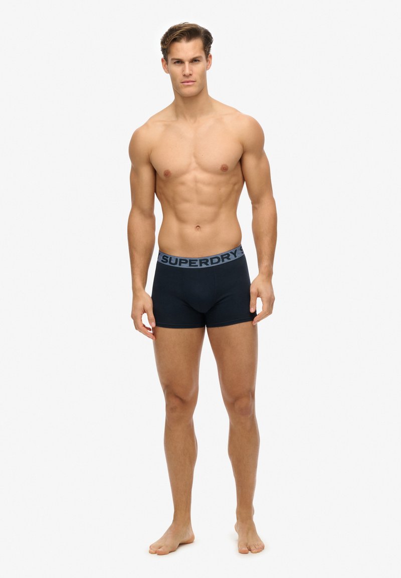 Boxer briefs neri con una ampia cintura blu a contrasto che presenta il logo "SUPERDRY". Design aderente e tessuto liscio.