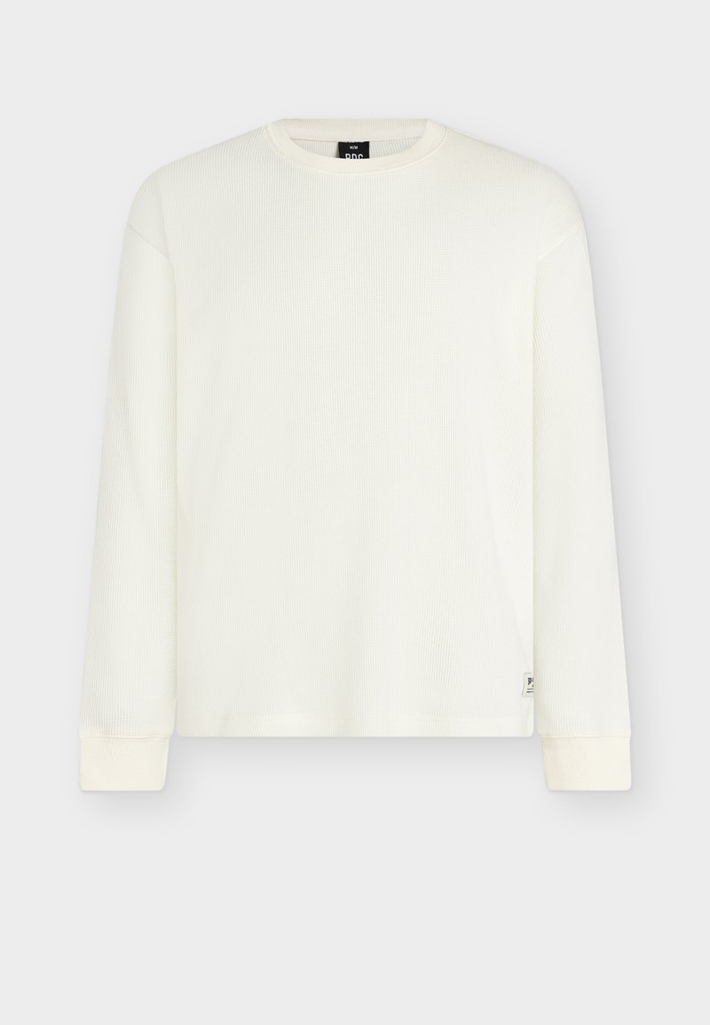 Λευκό ριγωτό πουκάμισο με μακριά μανίκια, στρογγυλή λαιμόκοψη και εφαρμοστά τελειώματα στα μανίκια. Διαθέτει μικρή ετικέτα με λογότυπο στο κάτω αριστερό μέρος. Απαλή υφή.