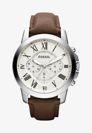 Montre en acier inoxydable argenté avec un cadran blanc, des chiffres romains, des sous-cadrans et un bracelet en cuir marron. Elle présente des accents polis et des détails texturés.