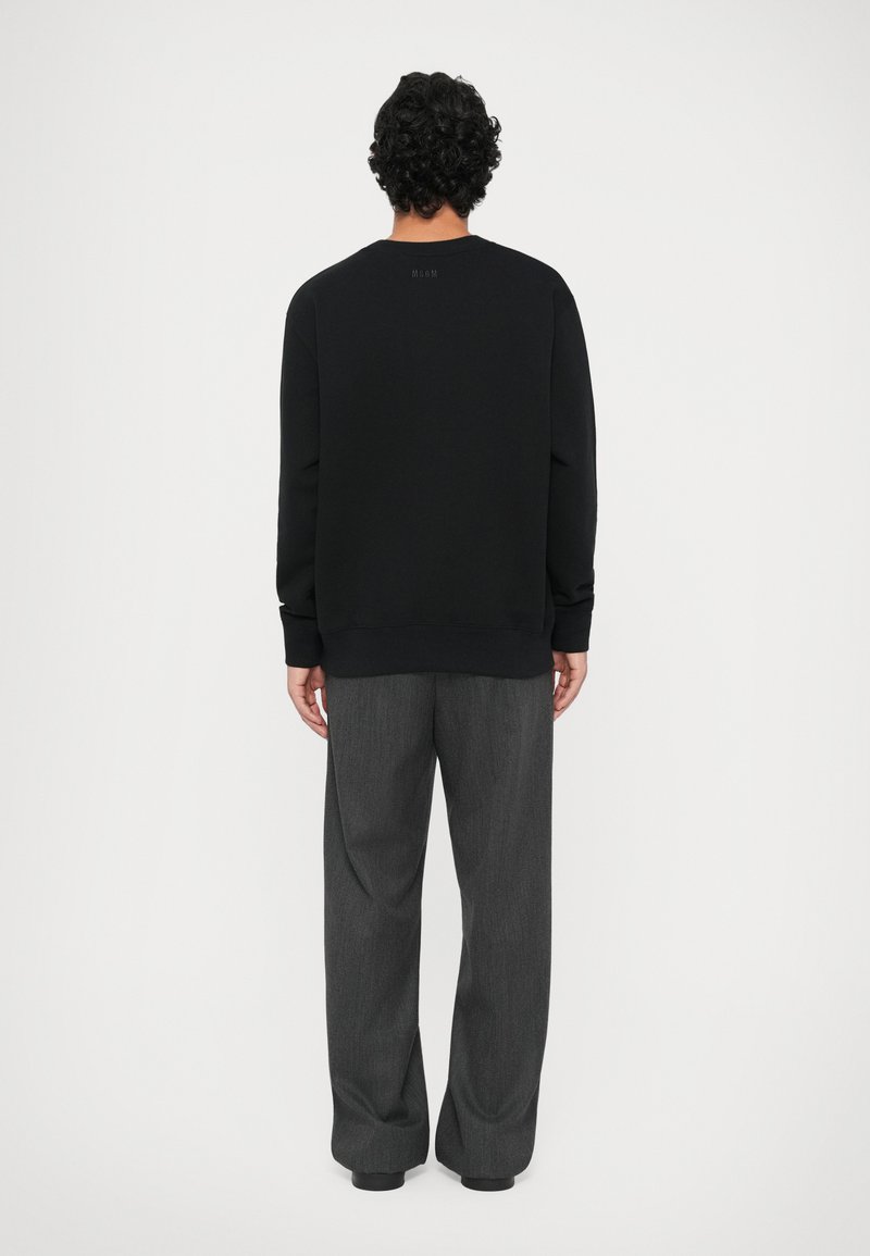 Zwart sweatshirt met geribbelde boorden en zoom, getoond vanuit de achterkant met grijze broek. Eenvoudig design, zachte textuur, geen zichtbare patronen.