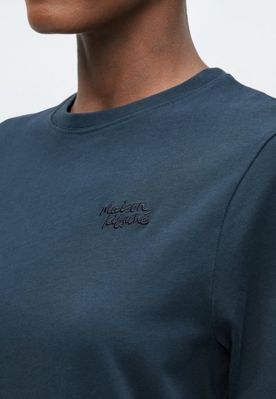 Námorně modré bavlněné tričko s kulatým výstřihem, zdobené vyšitým logem v mírně tmavším odstínu. Hladká textura, volný střih.