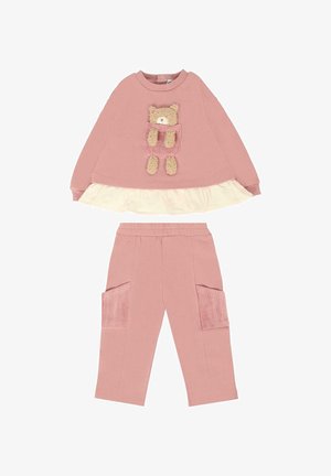Felpa rosa con design a orsetto e strati di rouches, abbinata a pantaloni rosa coordinati con tasche in corduroy. Tessuto morbido.