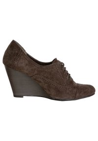 Chaussures à talon compensé en suede marron avec un laçage sur le devant, bout arrondi et détails cousus. Le talon compensé présente une texture nervurée pour une meilleure adhérence.