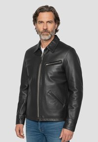 Schwarze Lederjacke mit Kragen, Frontreißverschluss und Seitentaschen. Glatte Textur und minimalistisches Design, mit einer Brusttasche mit Reißverschluss.