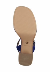 Modra sandal s zgornjim delom iz semiša in bež gumijastim podplatom. Ima nastavljiv trak okoli gležnja in strukturiran, vzorčen podplat za boljši oprijem.