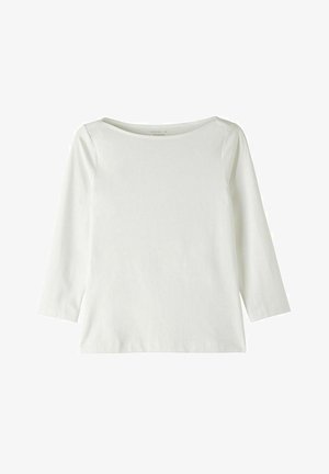 Top blanc à manches longues avec un col bateau. Fabriqué en tissu doux, il présente une texture lisse et une coupe légèrement loose.