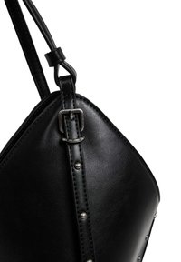 Borsa a tracolla in pelle nera con forma triangolare, caratterizzata da borchie color argento lungo la cucitura e una fibbia in metallo sulla tracolla.