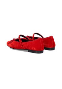 Bailarinas de ante rojo con suelas negras y detalle de tira decorativa. Textura suave con punta redondeada y sutiles acentos de costura.