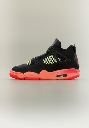 Czarny i neonowo zielony sneaker za kostkę z jasno-koralową podeszwą i detalem z poduszką powietrzną, widziany z boku na neutralnym tle.