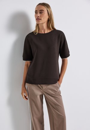 Bruine top met korte mouwen van een zachte stof, met een ronde hals en witte accents. Gecombineerd met beige broek met zijstrepen.