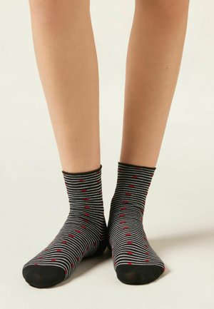 Černo-bílé pruhované ponožky se vzorem červených srdcí, délka ke střední části lýtka, vyrobené z měkkého pružného materiálu s černou špičkou.