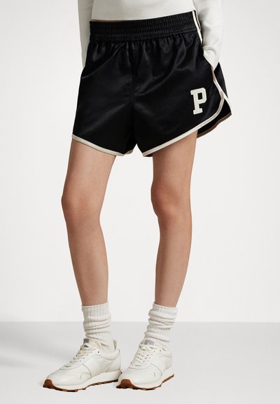 Shorts en satin noir avec un logo "P" blanc et un contraste de bord clair. Conçus avec une ceinture élastique pour le confort.