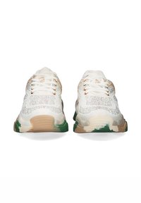 Zapatillas deportivas blancas con parte superior de tela texturada, acentos multicolores y suela gruesa en beige, verde y crema. Los cordones son blancos.