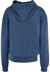 Felpa con cappuccio blu navy dal taglio rilassato, con polsini e orlo a coste. Realizzata in tessuto morbido con una texture liscia e design minimalista.