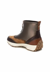 Brown suede and faux leather ankle boot with a rounded toe, textured accents, a white rubber sole, and a brown pull tab at the back.