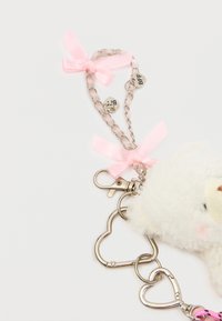 Bolyhos, fehér kulcstartó maci rózsaszín masnikkal, fém lánccal és szív alakú kapoccsal. "BFF" címkékkel rendelkezik. Puha tapintású, játékos dizájn.