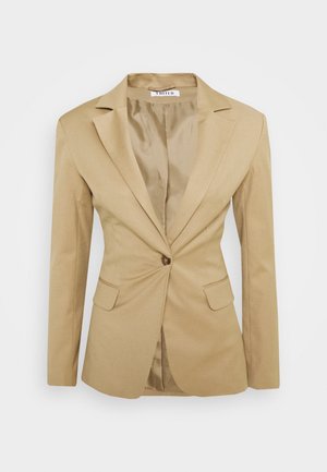 Beiger maßgeschneiderter Damenblazer mit einreihiger Knopfleiste, gekerbtem Revers, langen Ärmeln und Pattentaschen, präsentiert vor weißem Hintergrund.