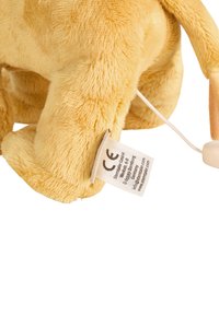 Plush toy with soft yellow fur, rounded shape, and prominent tag with CE marking. Features a hidden pull string for activation.