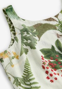 Tissu blanc avec des motifs de feuilles vertes et de fougères, accents floraux rouges et jaunes, présentant une encolure de vêtement sans manches et une bretelle d'épaule.