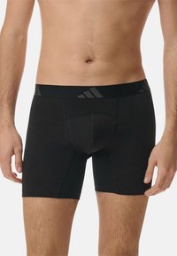 Zwarte atletische boxershorts met een strakke pasvorm, gemaakt van gladde stof. Heeft een zwarte tailleband met subtiele logodetails.