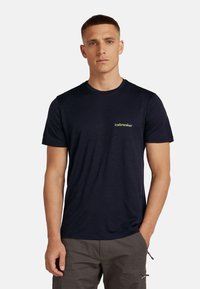Navy blauwe t-shirt met korte mouwen, gemaakt van zachte stof. Bevat een klein groen "icebreaker" logo op de linkerkant van de borst. Eenvoudig, klassiek ontwerp.