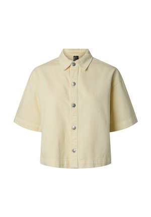 Chemisier court à manches courtes de couleur crème avec col et six boutons-pression argentés à l'avant, présenté sur un fond blanc uni.