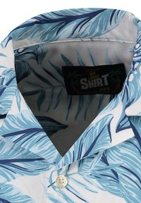 Kortebloemige shirt met een blauw loofpatroon op een witte achtergrond. Voorzien van een klassieke kraag en een knoopsluiting aan de voorkant. Maat S label zichtbaar.