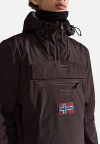 Brown, lightweight jacket with a zippered pocket, adjustable hood, and a Norwegian flag patch on the front. Features a textured fabric.