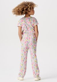 Dwuczęściowy strój w kwiatowy wzór w kolorze różowym, zielonym i żółtym. Krótki rękaw, bluzka z elastycznymi spodniami, wykonany z miękkiej, oddychającej tkaniny.