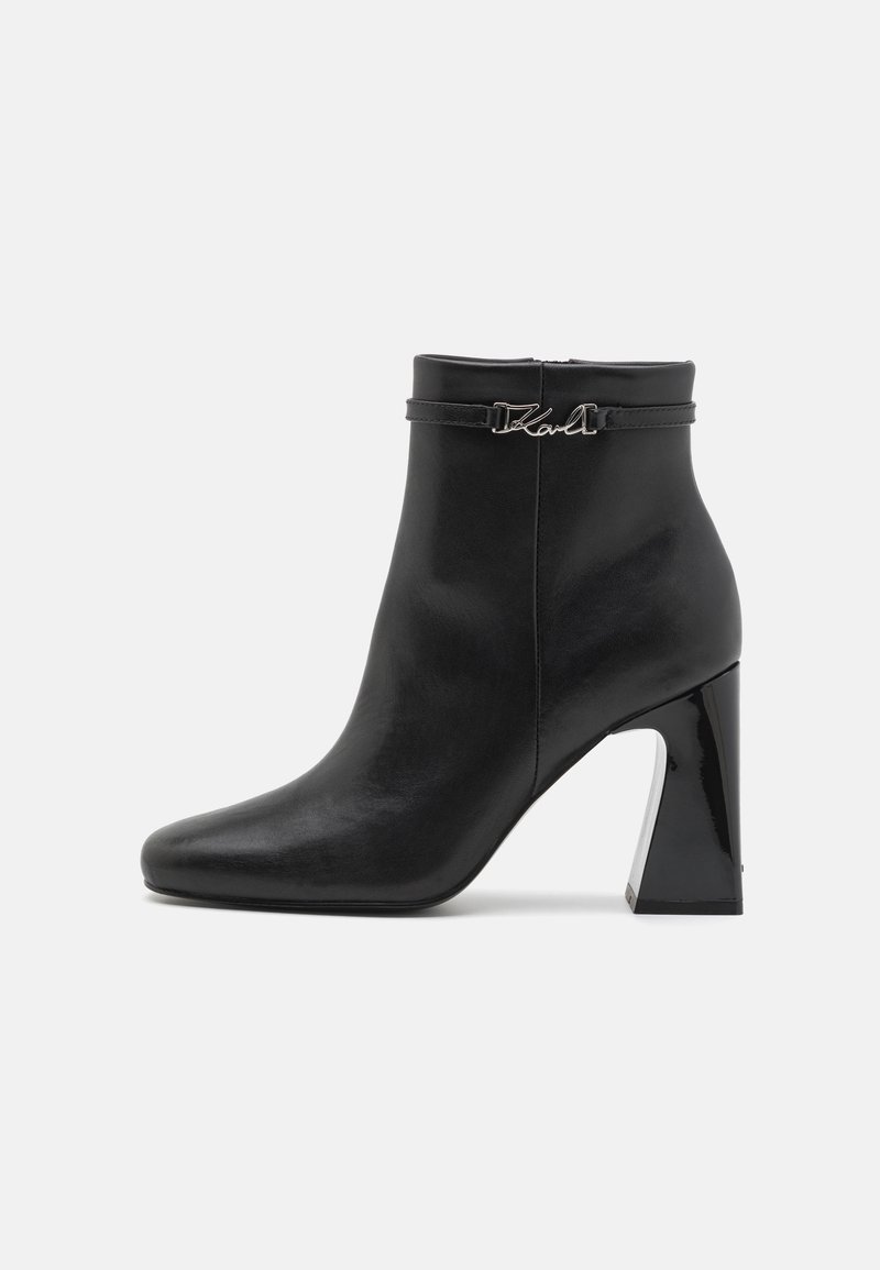 Bottine en cuir noir avec bout carré, talon bloc et petite bride ornée d'un détail signature "Karl" en argent sur le côté.