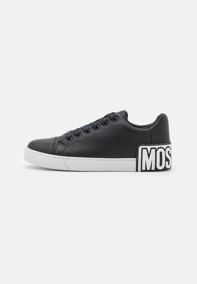 Black leather sneaker with a white rubber sole, textured surface, round toe, six eyelets, and a bold "MOS" graphic on the heel.