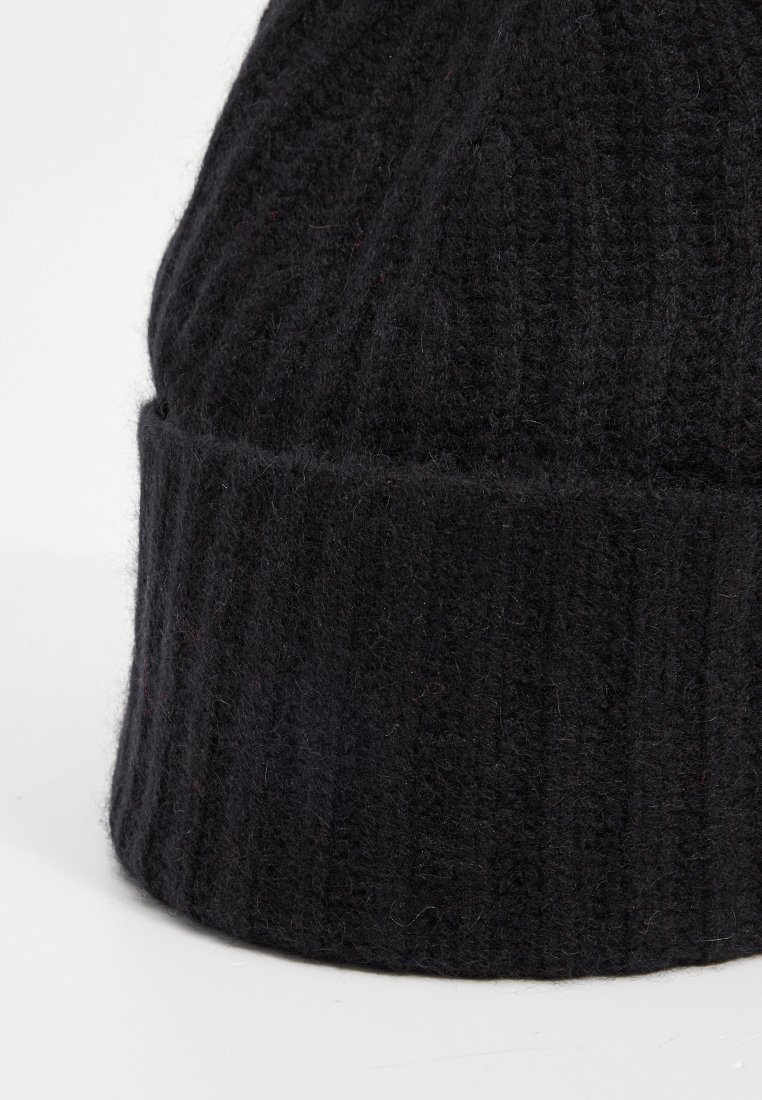 Czarna, prążkowana czapka beanie z miękkiej wełny. Posiada złożony mankiet i teksturowane wykończenie, zapewniając ciepło i komfort.