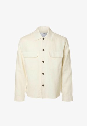 Camicia di lino off-white con chiusura a bottoni, due tasche sul petto, colletto classico e bottoni marroni. Maniche lunghe con polsini a bottoni.