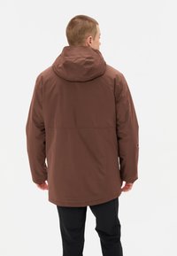 Veste imperméable marron avec une capuche rembourrée, des manches longues et une coupe ample. Texture lisse sans motifs visibles ni détails matériels.