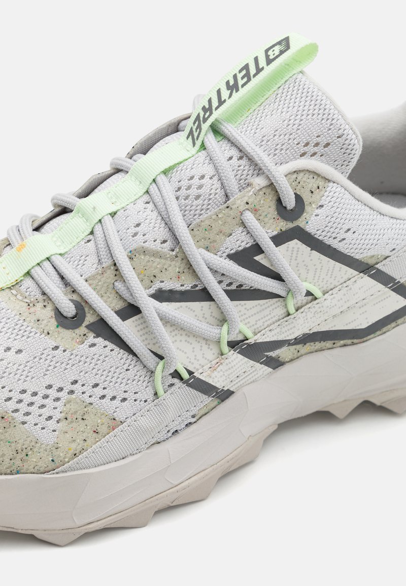 Hellegraue Netz-Laufschuhe mit gemischter Textur, grünen Akzenten, grauen Streifen und einer gemusterten, gepolsterten Sohle.