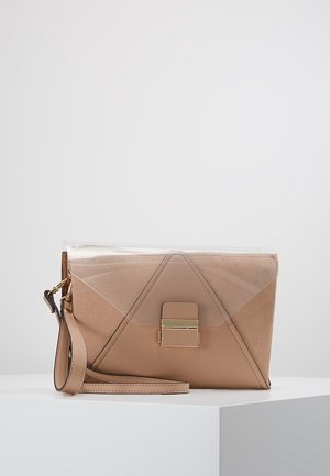 Beige leren en suède clutch met een transparante plastic flap en gouden gesp, rustend op een wit oppervlak met een aangehechte polsband.